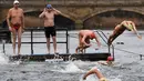 Peserta meluncur ke danau saat mengikuti lomba berenang di Danau Serpentine di Hyde Park, London, Inggris, Minggu (25/12). Lomba berenang di danau yang dingin ini sudah menjadi acara tahunan setiap perayaan natal. (REUTERS/Toby Melville)
