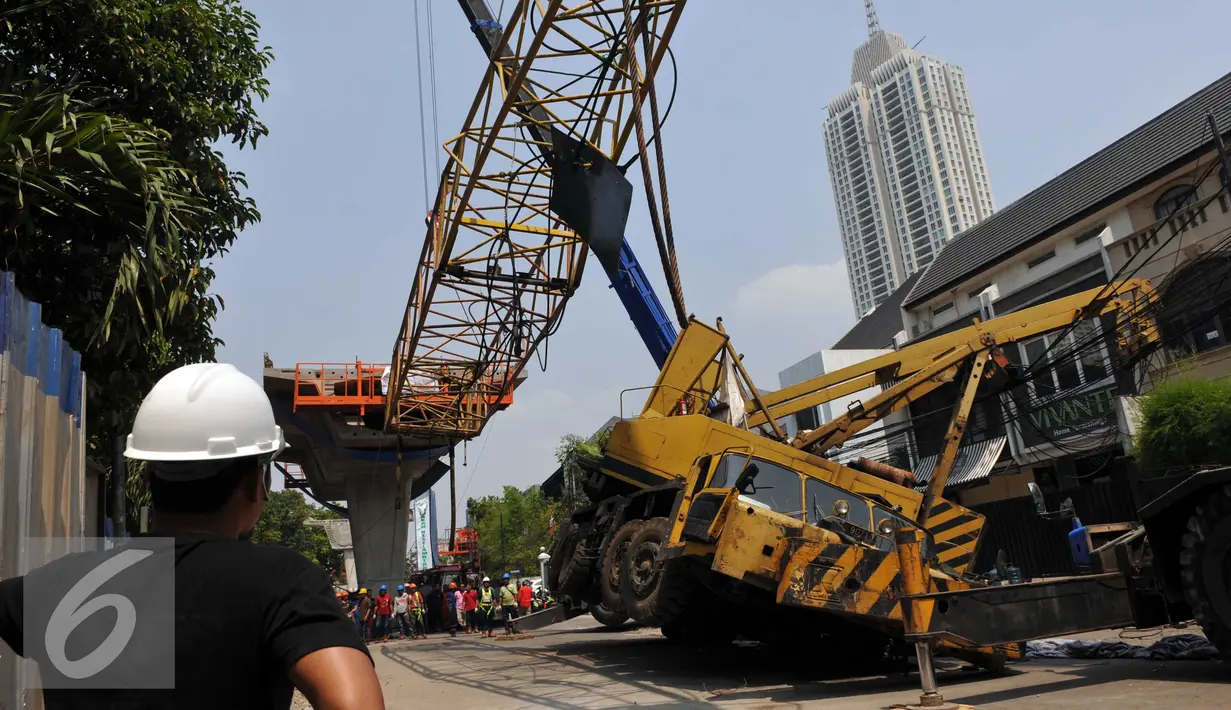 Pekerja mengevakuasi crane yang jatuh di Jalan Kyai Maja, Jakarta Selatan, Kamis (15/10/2015). Alat besar yang tengah melakukan proyek ‎jalan layang ini menimpa salah satu rumah warga yang berada di sisi kanan jalan. (Liputan6.com/Helmi Afandi)