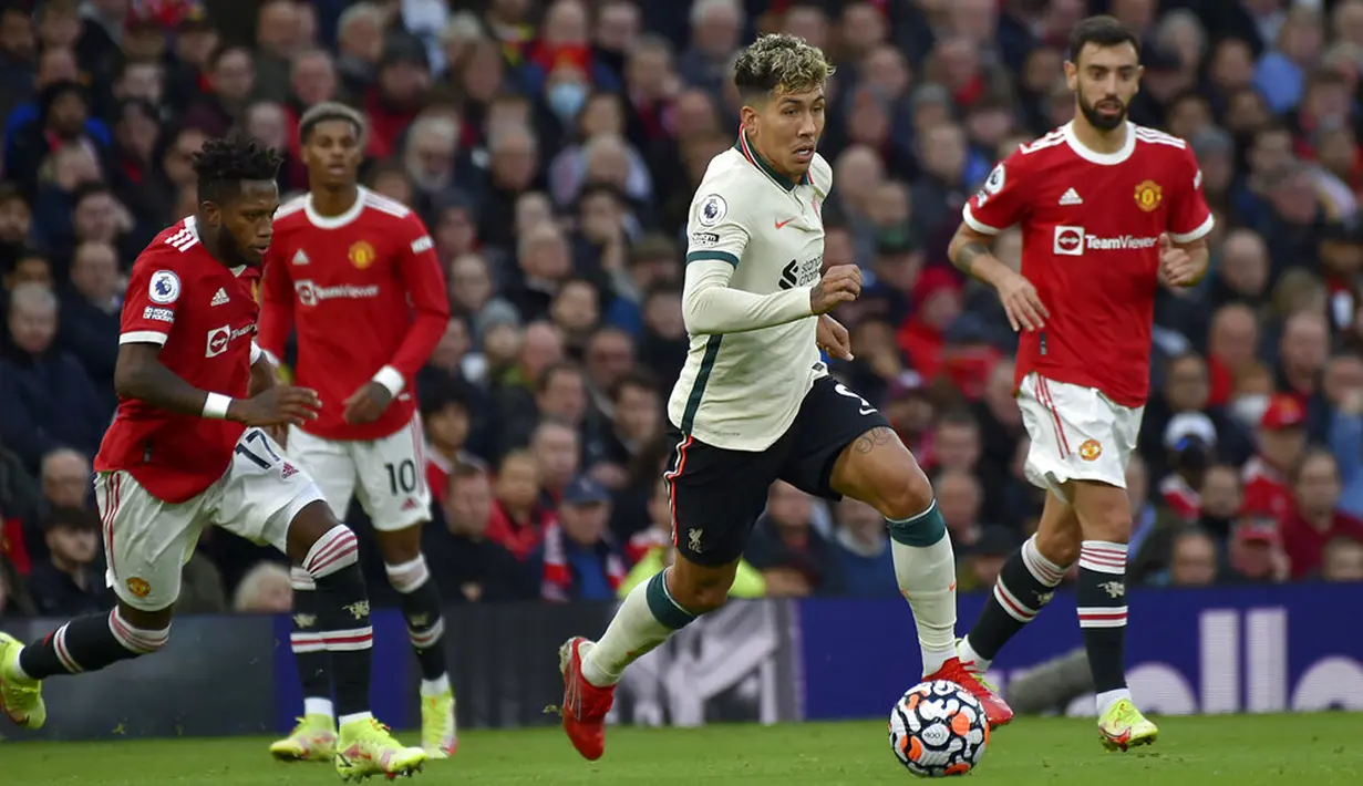 Pemain Liverpool Roberto Firmino (kedua kanan) menggiring bola menjauhi pemain Manchester United Fred (kiri) pada pertandingan Liga Inggris di Old Trafford, Manchester, Inggris, Minggu (24/10/2021). Liverpool menang 5-0. (AP Photo/Rui Vieira)