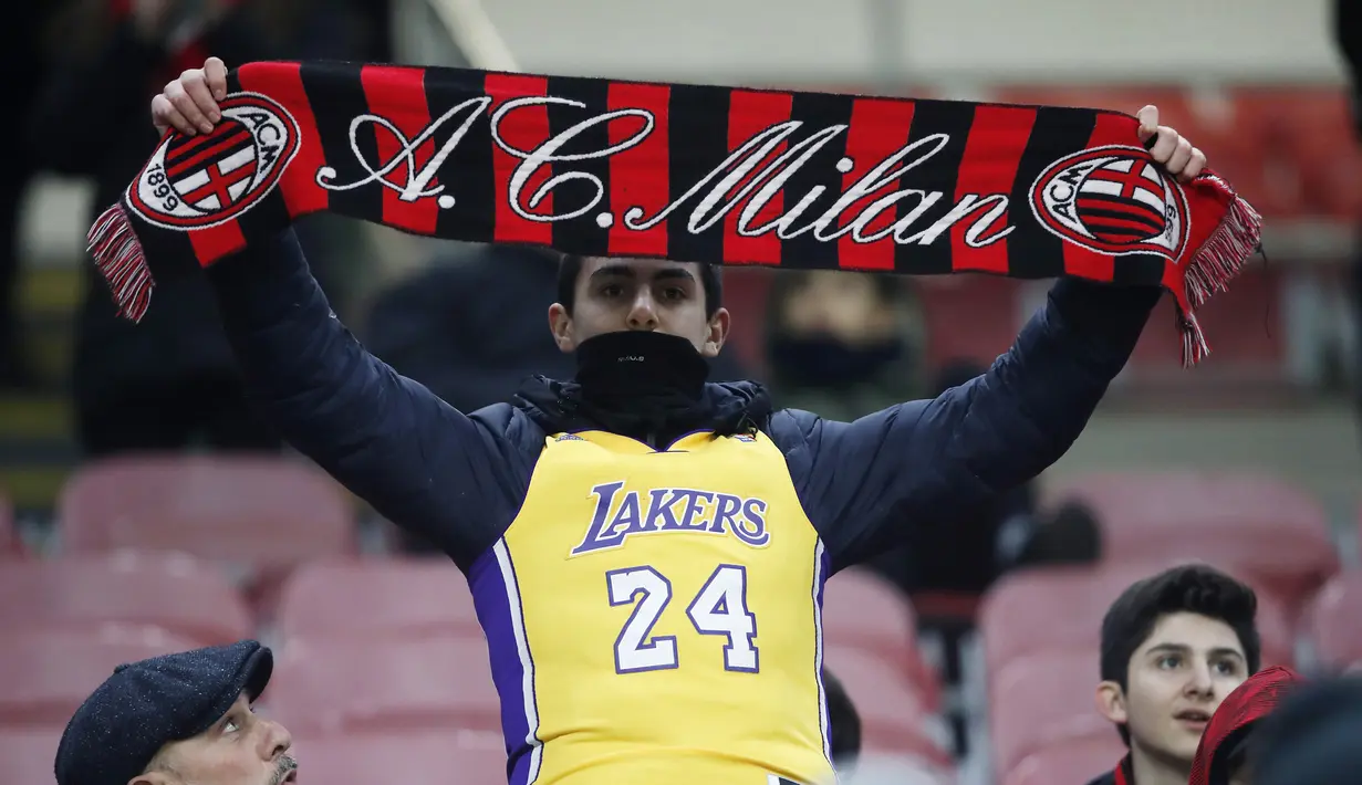 Pendukung AC Milan mengenakan jersey Kobe Bryant sebelum pertandingan AC Milan melawan Torino pada perempat final Coppa Italia di stadion San Siro (28/1/2020). Kobe Bryant yang berusia 41 tahun  meninggal bersama putrinya Gianna akibat kecelakaan helikopter. (AP Photo/Antonio Calanni)