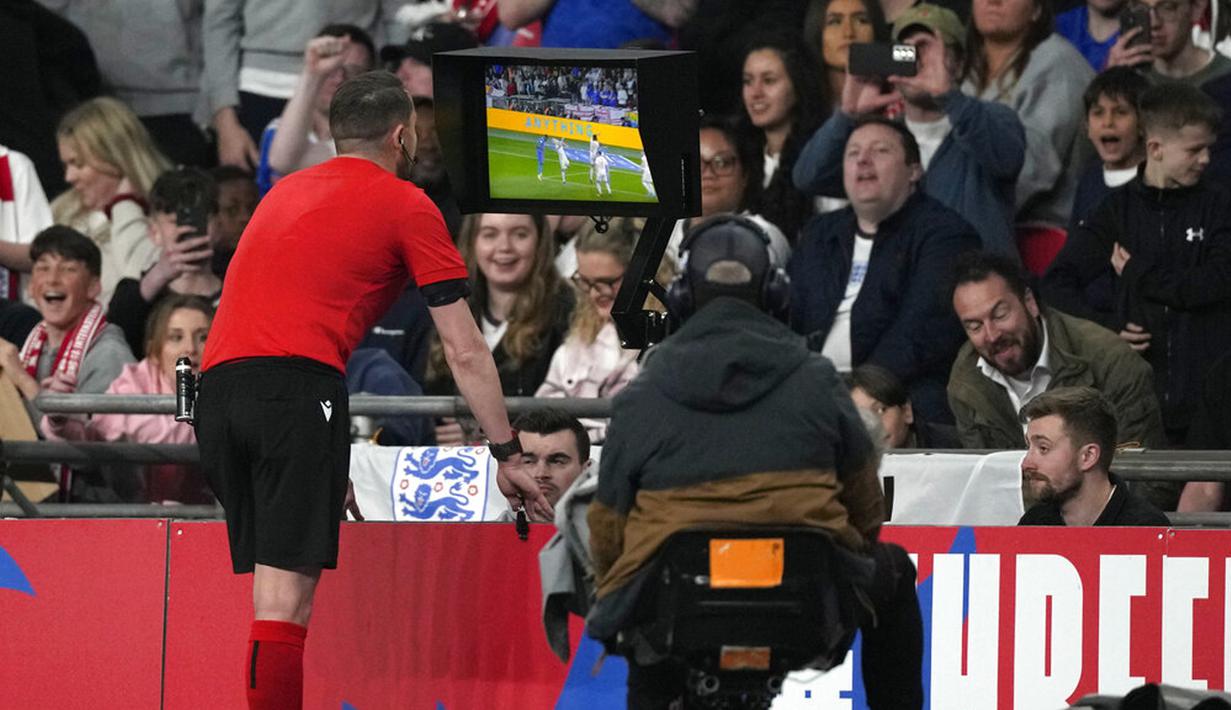 Wasit Andreas Ekberg memeriksa VAR sebelum memberikan penalti kepada Inggris saat melawan Swiss pada pertandingan uji coba di Stadion Wembley, London, Inggris, 26 Maret 2022. Inggris menang 2-1. (AP Photo/Alastair Grant)