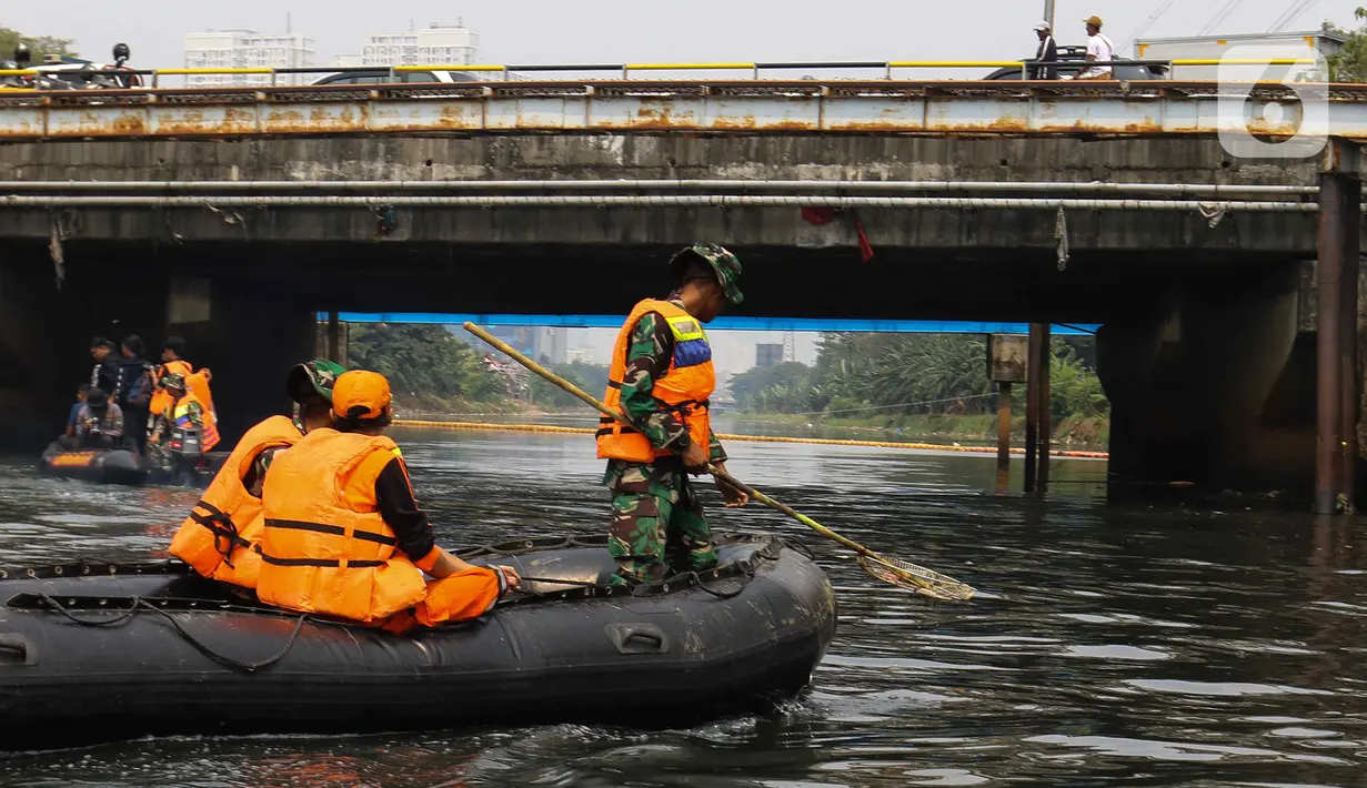 Personel gabungan membersihkan sampah di bawah jembatan saat kegiatan Grebeg Kali Ciliwung. (Liputan6.com/Herman Zakharia)