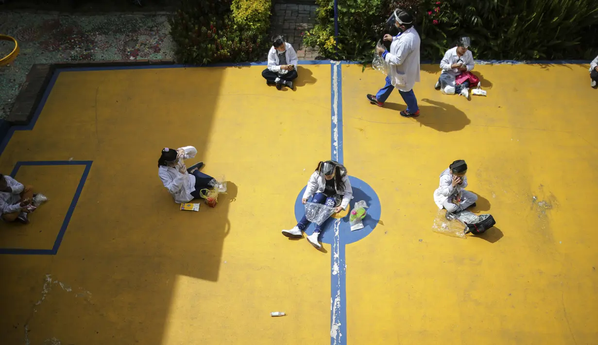 Siswa menjaga jarak sosial saat waktu camilan pada hari pertama kembali ke kelas tatap muka sejak Maret 2020 di Liceo Lunita, sebuah sekolah swasta di Chia di pinggiran Bogota, Kolombia, Jumat (5/2/2021). Sejauh ini Kolombia melaporkan lebih dari 2,13 juta kasus Covid-19. (AP Photo/Ivan Valencia)