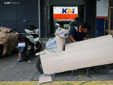 Pekerja mengemas motor untuk dikirim melalui salah satu jasa pengiriman logistik di kawasan Pasar Senen, Jakarta, Minggu (23/3/2025). (Liputan6.com/Herman Zakharia)