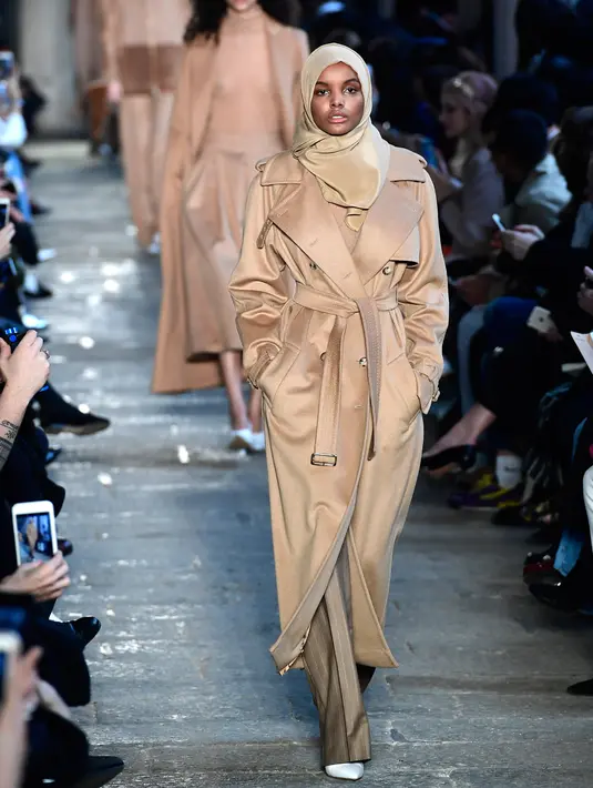 Model Amerika-Somalia, Halima Aden berjalan di runaway Milan Fashion Week membawakan koleksi Max Mara women's Fall/Winter 2017-2018 di Milan, Kamis (23/2). Halima Aden menjadi satu-satunya model berhijab dalam show tersebut. (Miguel MEDINA/AFP)