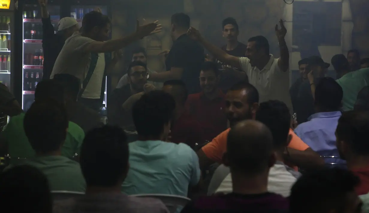 Warga Palestina merayakan gol saat laga El Clasico antara Barcelona melawan Real Madrid di West Bank City, Ramallah, Minggu (6/5/2018). Konflik perang tak menyurutkan fenomena El Clasico. (AFP/Abbas Momani)