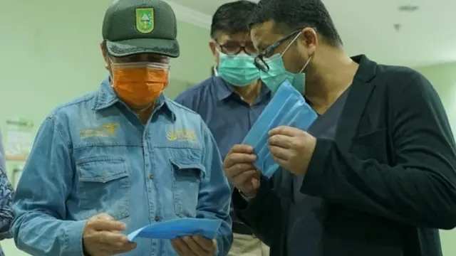 Gubernur Riau Syamsuar melihat masker kain buatan relawan sebelum dibagikan kepada masyarakat terdampak covid-19.