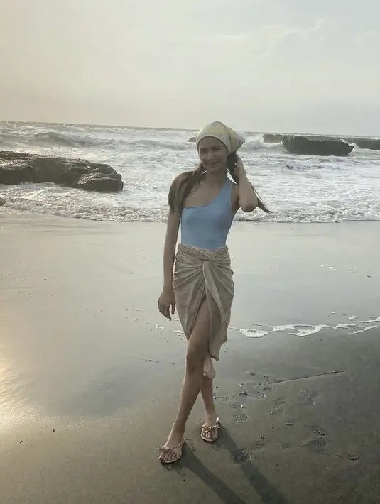 Tubuh langsing dambaan para perempuan juga diperlihatkan Mikha ketika mengenakan bikini baby blue yang dipadukan dengan kain. (@miktambayong)