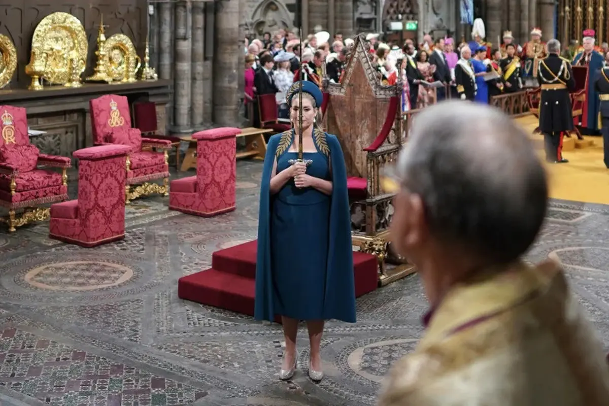 Ketua House of Commons Parlemen Inggris, Penny Mordaunt, mempersembahkan pedang ke Raja Charles III dalam proses penobatannya di Westminster Abbey, London 6 Mei 2023 (Pool Photo)