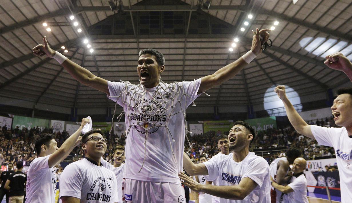 Pebasket Stapac Jakarta, Muhammad Thoyib, merayakan gelar juara usai mengalahkan Satria Muda Jakarta pada laga final IBL 2019  di C-Tra Arena, Bandung, Sabtu (23/3). Stapac menang 74-56 atas Satria Muda. (Bola.com/M Iqbal Ichsan)
