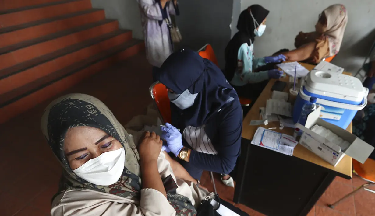 Warga menerima suntikan vaksin virus corona COVID-19 Sinovac di Stadion Patriot Candrabhaga, Bekasi, Kamis (28/10/2021). Indonesia melihat ke depan dengan waspada akan gelombang ketiga COVID-19 selama perjalanan liburan yang akan datang. (AP Photo/Achmad Ibrahim)