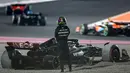 Pembalap Mercedes, Lewis Hamilton berdiri disamping mobilnya setelah mengalamai kecelakaan dalam  Formula One Qatar 2023 yang berlangsung di Lusail International Circuit, Minggu (8/10/2023). (AFP/Giuseppe Cacace)