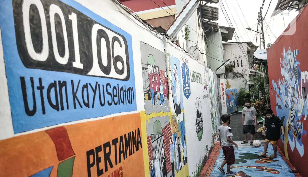 Anak-anak bermain bola di salah satu gang Kampung Sehat, Utan Kayu Selatan, Jakarta, Rabu (11/11/2020). Kampung Sehat ini diisi berbagai tanaman hidroponik, kolam ikan, mural 3D, dan fasilitas protokol kesehatan 3M. (merdeka.com/Iqbal S. Nugroho)