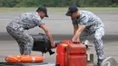 Dua orang personil militer Singapura meletakkan barang bantuan dengan hati-hati, Pangkalan Bun, Kalteng, Kamis (1/1/2015). (Liputan6.com/Herman Zakharia)