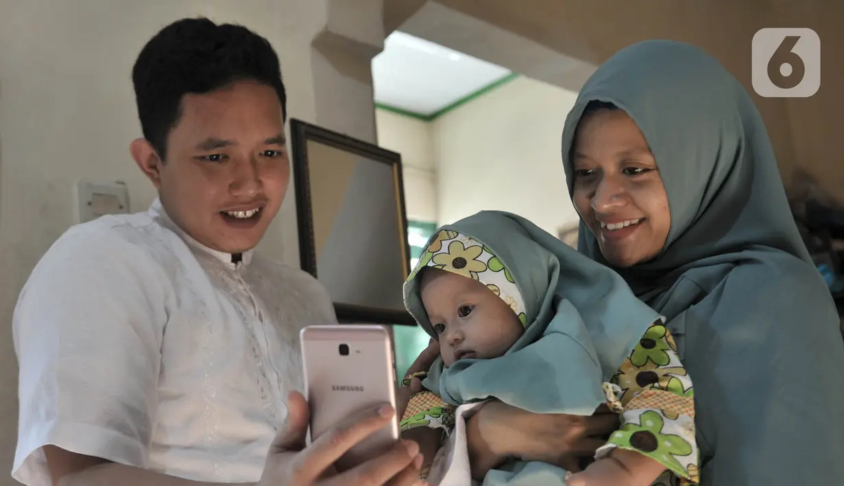 Warga bermaaf-maafan dengan keluarga melalui panggilan video saat halalbihalal Idul Fitri di Jakarta, Minggu (24/5/2020). Halalbihalal virtual menjadi alternatif bersilaturahmi dengan keluarga di kampung halaman akibat tidak dapat mudik karena wabah virus COVID-19. (merdeka.com/Iqbal S. Nugroho)