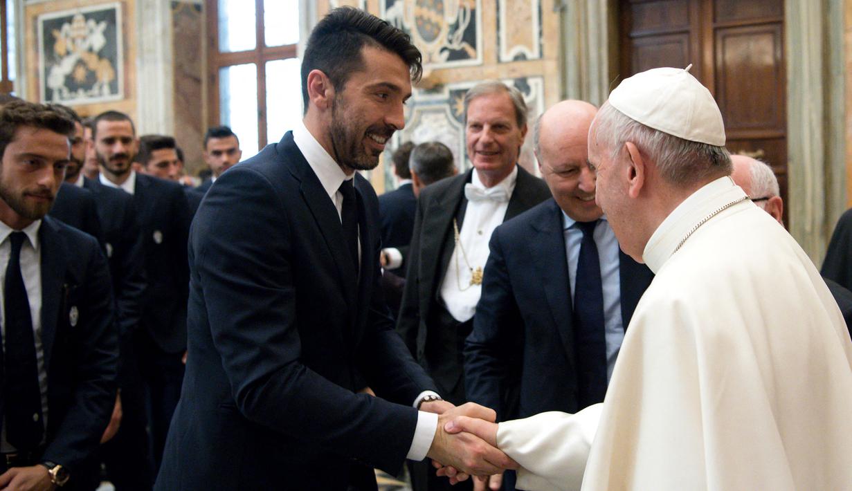 Paus Fransiskus (kanan) bersalaman dengan Kiper Juventus, Gianluigi Buffon di akhir audiensi dengan pemain Juventus dan Lazio pada malam menjelang final Piala Tim pada 16 Mei 2017. (AFP/Osservatore Romano)