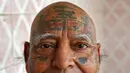 Guinness Rishi saat menunjukan tato di bagian kepalanya di apartemennya di New Delhi, India (20/5). Guinness Rishi merupakan pemegang rekor dunia yang paling banyak menato bendera negara dari seluruh dunia. (REUTERS/Cathal McNaughton)
