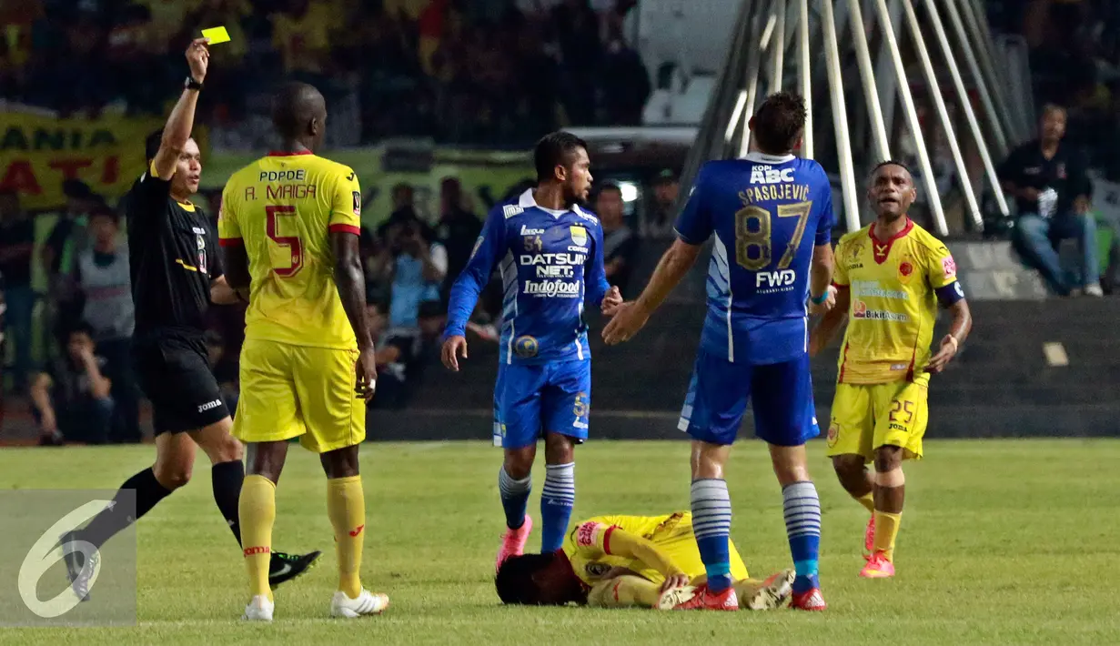 Wasit Djumadi Effendi (kiri) memberikan kartu kuning pada Penyerang Persib Spasojevic (kedua kanan) pada Piala Presiden 2015 di stadion GBK, Jakarta, Minggu (18/10/2015). Persib menang atas Sriwijaya dengan skor 2-0. (Liputan6.com/Yoppy Renato)