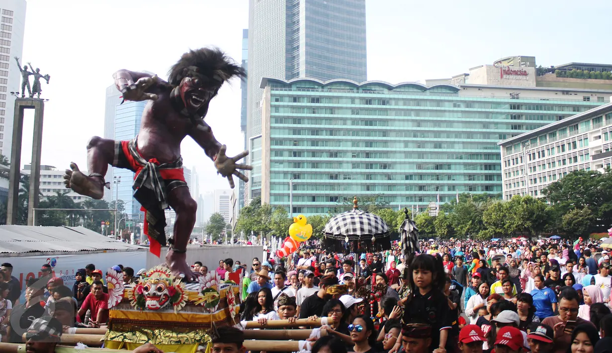 Suasana pengarakan ogoh-ogoh di kawasan CFD, Bundaran HI, Jakarta, Minggu (19/3). Pawai ogoh-ogoh akan diadakan secara besar di Pura Agung Wira Satya Bhuana jelang menyambut Nyepi, Jakarta, pada Senin (27/3). (Liputan6.com/Angga Yuniar)