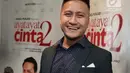 Pemain film Ayat-Ayat Cinta 2, Arie Untung tersenyum dengan setelan jas usai konferensi pers di Jakarta, Kamis (7/12). Arie Untung berperan sebagai Misbah di film tersebut. (Liputan6.com/Herman Zakharia)