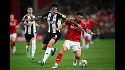 Pemain Newcastle, Sandro Tonali (kiri) berebut bola dengan pemain Nottingham Forest, Alex Moreno saat laga Carabao Cup 2024/2025 di City Ground, Nottingham, Inggris, Kamis (29/08/2024) WIB. (AFP/Paul Ellis)