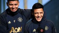 Pemain Manchester United, Marcos Rojo dan Alexis Sanchez, tersenyum saat latihan jelang laga 16 besar Liga Champions di Kompleks Carrington, Manchester, Senin (11/2). MU akan menjamu PSG pada leg pertama di Stadion Old Trafford. (AFP/Franck Fife)