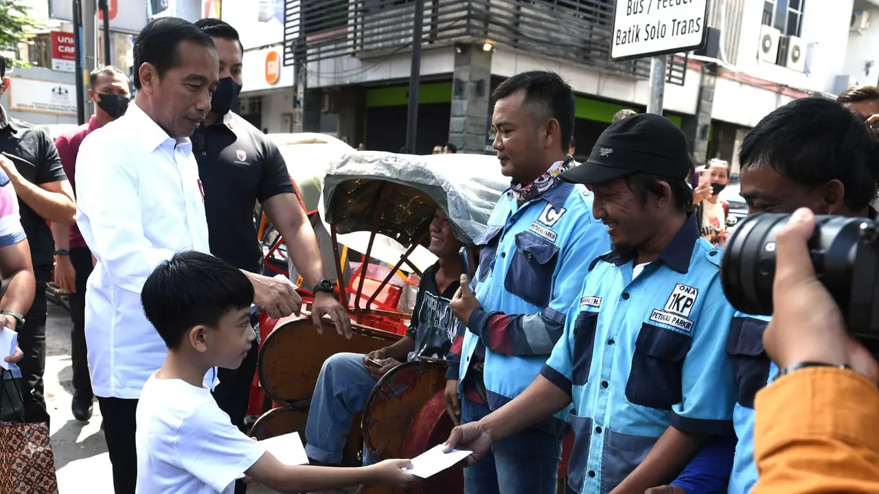 Presiden Jokowi dan Ibu Iriana yang turut mengajak cucunya, Jan Ethes Srinarendra membagikan sejumlah bantuan dan sembako kepada warga di Solo, Minggu (9/4/2023).
