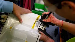 Founder sekaligus CEO Facebook, Mark Zuckerberg memberikan tanda tangan pada stiker inspeksi mobil Ford saat kunjungan ke pabrik mobil pikap legendaris Ford F-150 di Dearborn, Michigan, AS. (Facebook/Mark Zuckerberg)