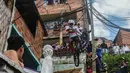 Warga menyaksikan aksi seorang pengendara sepeda saat mengikuti balapan Urban Bike Inder Medellin di gubuk comuna 1 di Medellin, Antioquia department, Kolombia (19/11). (AFP Photo/Joaquin Sarmiento)