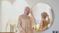 Gamis berbahan satin yang dilapisi brokat dapat memberikan kesan berkelas pada penampilanmu. (Instagram/emyaghnia).