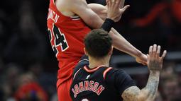 Aksi pemain Chicago Bulls, Lauri Markkanen (24) mengumpan bola saat diadang pemain Miami Heat, Tyler Johnson (8) pada laga NBA basketball game di United Center, Chicago, (26/11/2017). Miami Heat menang 100-93.  (AP/Paul Beaty)