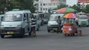 Pedagang kaki lima menjajakan dagangannya di depan angkot yang menunggu penumpang di Terminal Kampung Melayu, Jakarta, Jumat (2/8/2019). Gubernur DKI Anies Baswedan melalui Kepala Dinas Perhubungan menyiapkan rancangan peraturan daerah tentang pembatasan usia kendaraan. (merdeka.com/Imam Buhori)