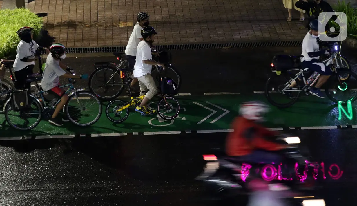 Pegiat bersepeda dan aktivis pecinta lingkungan saat aksi gowes Kelap Kelip Jakarta Night Ride #NOP26 di Jalan Jenderal Sudirman, Jakarta, Jumat (26/11/2021). Aksi ini mendorong pemimpin dunia berkomitmen meningkatkan tingkat bersepeda untuk mengurangi emisi karbon. (Liputan6.com/Helmi Fithriansyah)