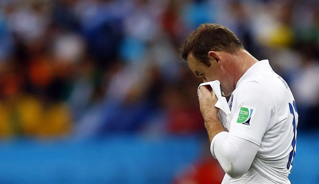 Pemain depan Timnas Inggris, Wayne Rooney menyeka wajahnya usai dikalahkan Uruguay 1-2 di babak penyisihan Piala Dunia 2014 Grup D di Stadion Corinthians, Sao Paulo, Brasil, (20/6/2014). (REUTERS/Ivan Alvarado) 