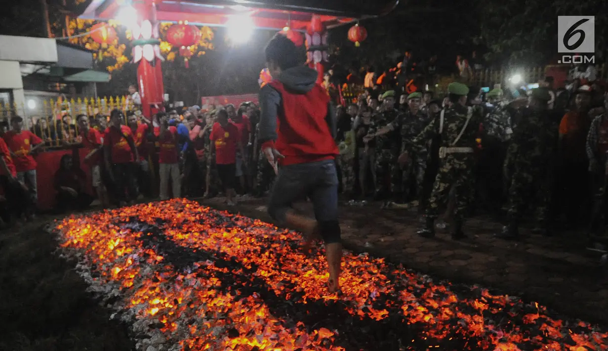 Warga melakukan atraksi Tahwe atau menginjak bara api di Hok Tek Bio Cibinong, Bogor, Sabtu (17/3). Ritual injak bara ini Ritual injak bara dimaksudkan sebagai upaya menolak bala untuk memohon keselamatan. (Merdeka.com/Arie Basuki)