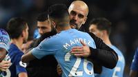 Pelatih Manchester City, Pep Guardiola, memeluk Riyad Mahrez, usai mengalahkan Chelsea pada laga Premier League di Stadion Etihad, Manchester, Sabtu (23/11). City menang 2-1 atas Chelsea. (AFP/Oli Scarff)