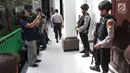 Awak media mengambil gambar personel kepolisian bersenjata lengkap di luar ruang sidang vonis dengan terdakwa Aman Abdurrahman di PN Jakarta Selatan, Jumat (22/6). Sidang pembacaan vonis Aman ini tertutup bagi para awak media. (Liputan6.com/Angga Yuniar)