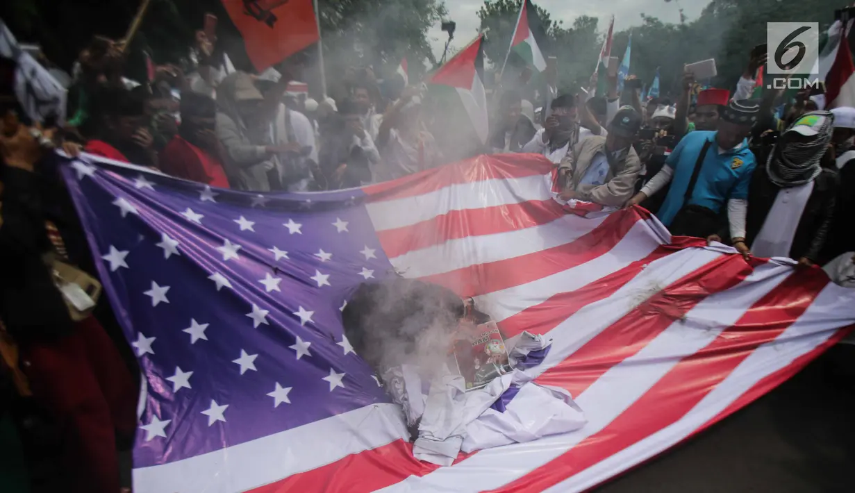 Massa aksi bela Palestina membakar bendera Amerika Serikat (AS) saat berunjuk rasa di depan Kedubes AS, Jakarta, Senin (11/12). Massa memprotes kebijakan Presiden Donald Trump yang mengakui Yerusalem sebagai Ibu Kota Israel. (Liputan6.com/Faizal Fanani)