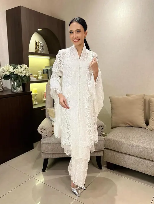 Artika Sari Devi tampil dengan setelan putih lace dari atasan baju kurung dan rok panjang. Lengkap dengan selendang yang bisa menutupi kepala. [@saliyane]