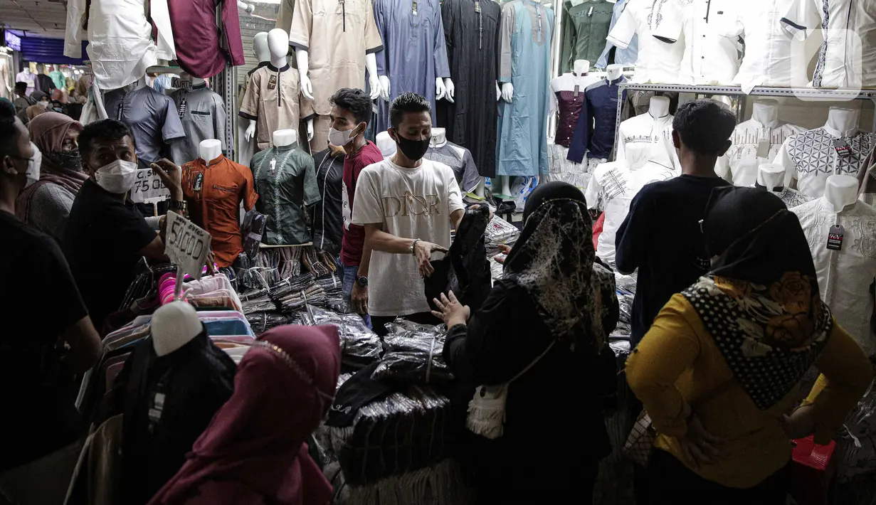 Pedagang melayani pembeli perlengkapan ibadah di Pasar Tanah Abang Blok A, Jakarta, Senin (4/4/2022). Penjualan busana muslim seperti mukena, kerudung, sajadah dan sarung mengalami peningkatan di bulan Ramadhan. (Liputan6.com/Faizal Fanani)