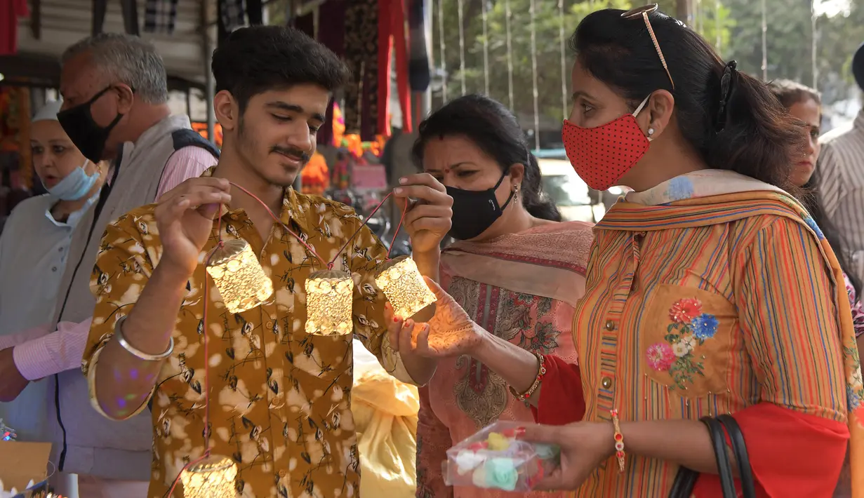 Orang-orang membeli barang-barang dekorasi menjelang festival Diwali di sebuah pasar di Amritsar, India pada 10 November 2020. Tahun ini festival lampu Diwali jatuh pada 14 November mendatang. (Photo by NARINDER NANU / AFP)