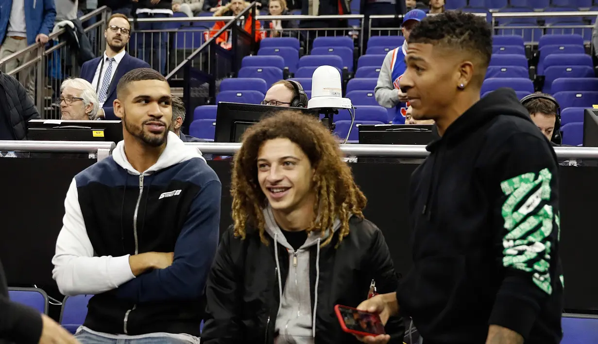 Pemain Chelsea Ruben Loftus-Cheek bersama Ethan Ampadu dari Chelsea dan pemain Cristal Palace Patrick van Aanholt menyaksikan basket NBA London Game 2019 antara Washington Wizards dan New York Knicks di London (17/1). (AP Photo/Alastair Grant)