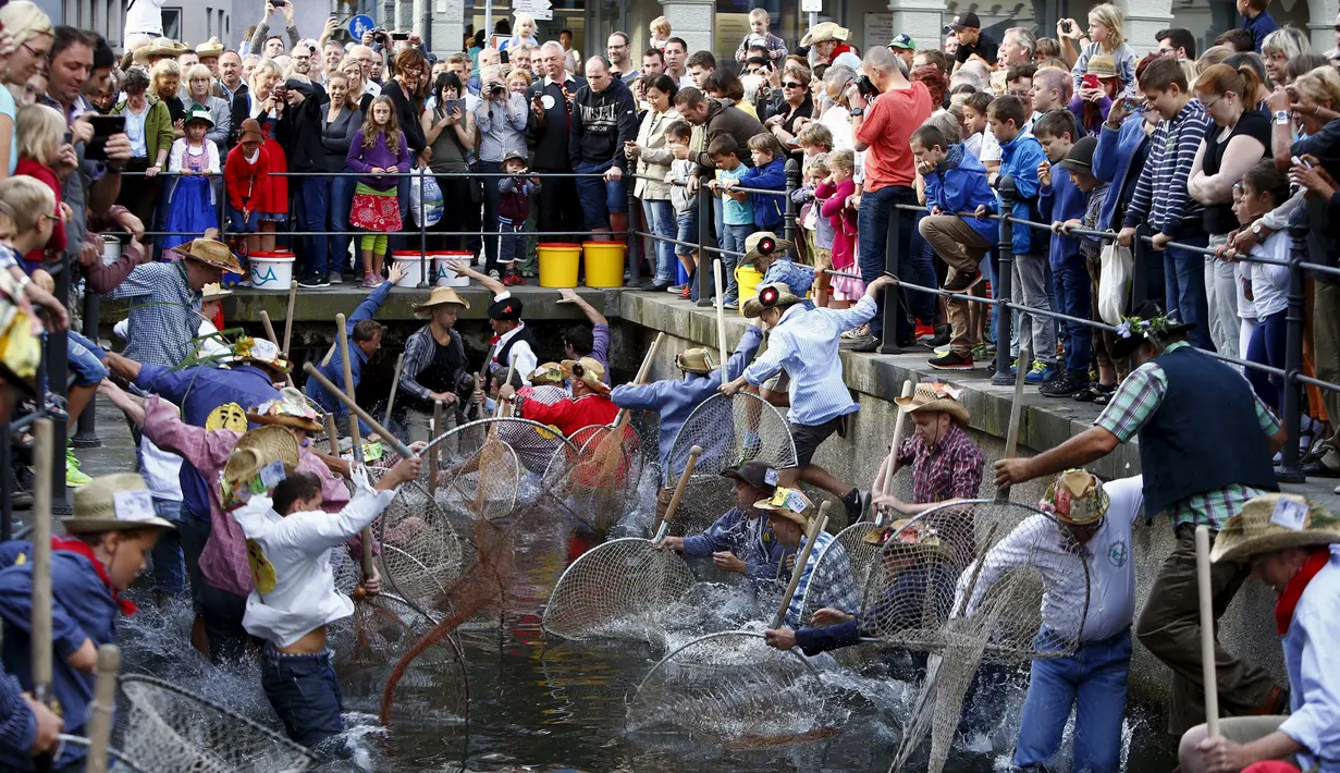 Puluhan nelayan turun ke sungai untuk menangkap ikan saat hari nelayan di Memmingen, Jerman, Sabtu (25/7/2015). Tradisi ini sudah ada sejak tahun 1465 dimana setiap nelayan yang lahir di Memmigen harus menangkap ikan di sungai. (REUTERS/Michaela Rehle)