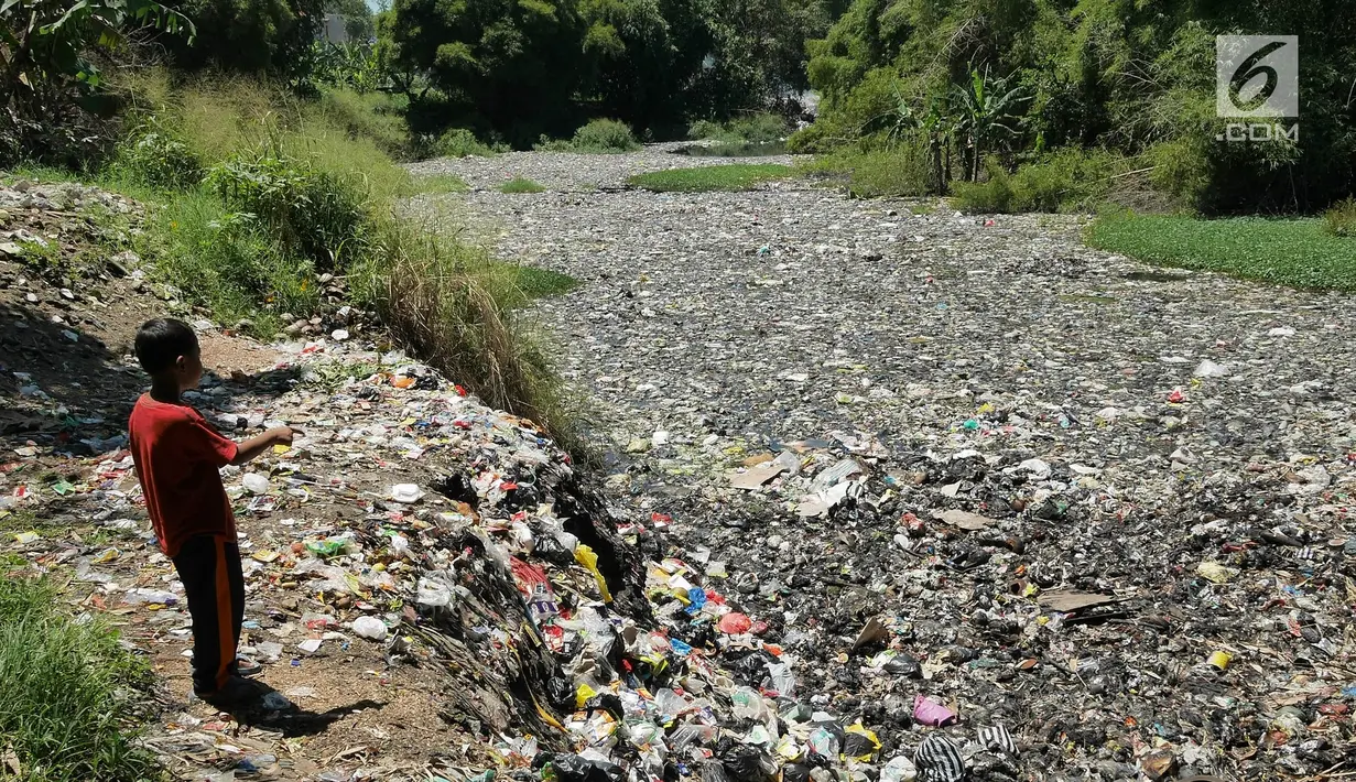 Seorang anak bermain di Sungai Citarum Lama yang penuh sampah, Cicukang, Bandung, Jawa Barat, Rabu (3/4). Pemerintah pusat menggagas program Citarum Harum untuk merevitalisasi sungai terpanjang di Jawa Barat tersebut. (Liputan6.com/Herman Zakharia)