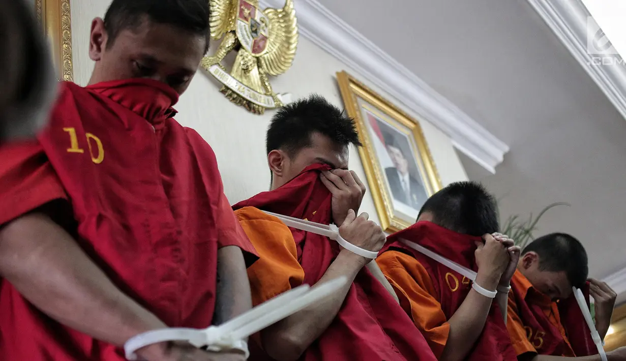 Tersangka kasus order fiktif pada transportasi online saat dihadirkan di Polda Metro Jaya, Jakarta, Rabu (13/2). Polisi membekuk empat tersangka dalam kasus ini. (Liputan6.com/Faizal Fanani)