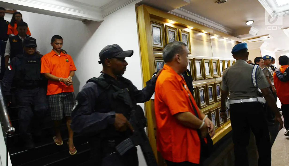 Polisi bersenjata menggiring tersangka dugaan pengaturan skor di Polda Metro Jaya, Jakarta, Rabu (10/4). Para tersangka itu berkaitan dengan laporan Manajer Persibara Banjarnegara Lasmi Indaryani. (merdeka.com/Imam Buhori)