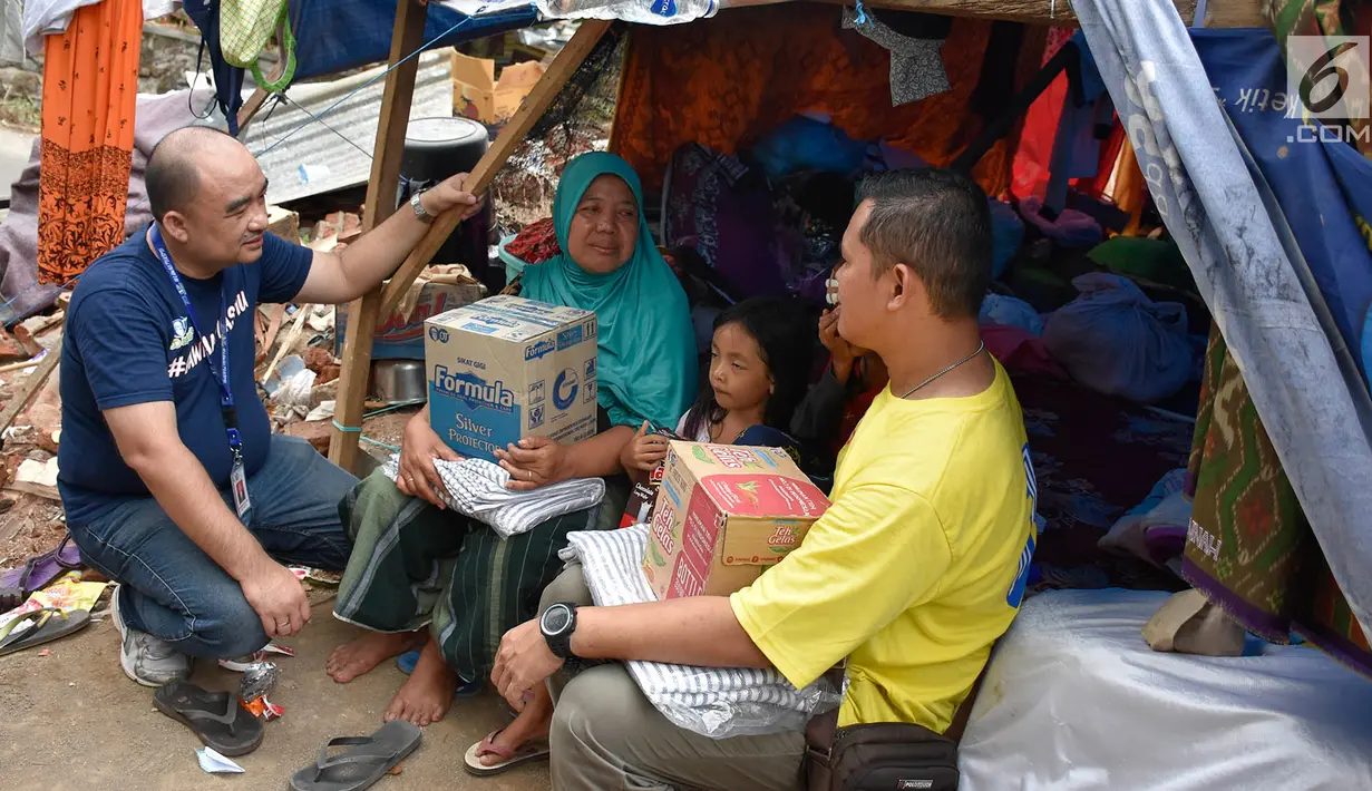 Warga berbincang dengan pimpinan OT Peduli mendistribusikan bantuan berupa paket sembako, obat-obatan, perlengkapan bayi, biskuit hingga air kemasan untuk korban gempa di wilayah Lombok Utara, NTB (21/8). (Liputan6.com/HO/Iwan)