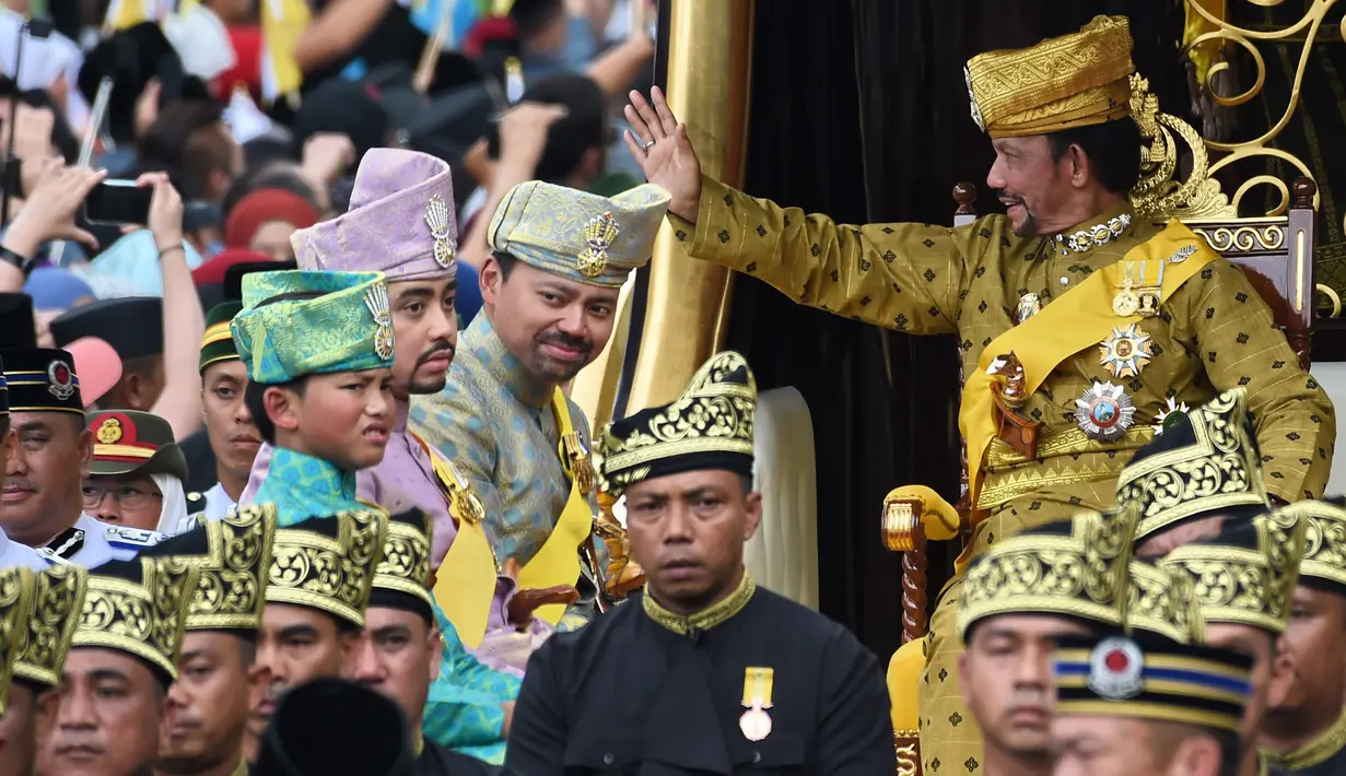 <p>Sultan Hassanal Bolkiah saat naik kereta kerajaan melambaikan tangan kepada warga sekitar selama prosesi Golden Jubilee di Bandar Seri Begawan (5/10). Perayaan tersebut menandai 50 tahun bertahta. (AFP PHOTO / Roslan Rahman)</p>