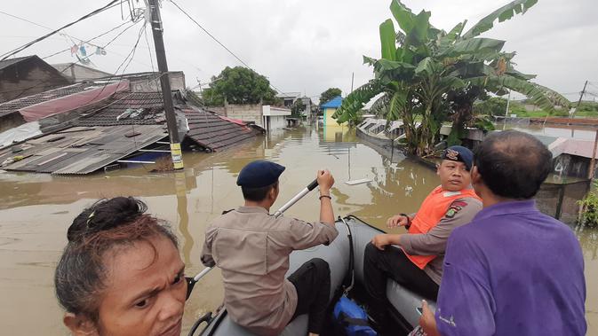 Kepolisian melakukan patroli menggunakan perahu karet ke lokasi banjir di Kota Tangerang, Selasa (4/2/2020). (Pramita Tristiawati/Liputan6.com)