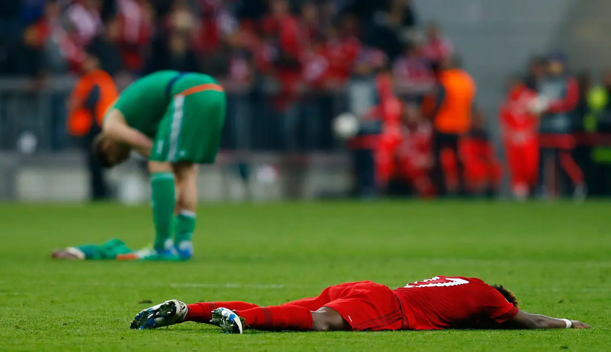 Bek Muenchen, David Alaba tergeletak di tengah lapangan usai pertandingan melawan Atletico Madrid di semifinal Liga Champions di Allianz Arena (4/5). Atletico melaju ke final dengan aggregat gol tandang. (Reuters/Ralph Orlowski)